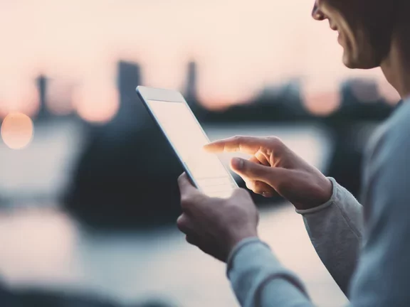 Young man texting on a tablet